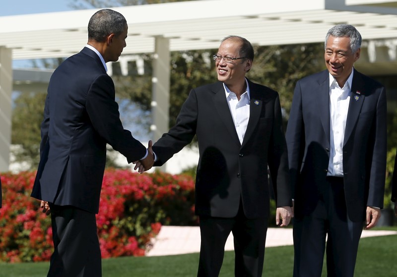 © Reuters. U.S. President Obama shake hands with Philippine President Aquino as Singapore Prime Minister Lee looks on as leaders from the ASEAN summit finish taking a family photo in Rancho Mirage