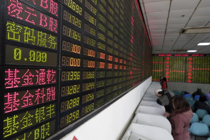 © Reuters. Investors look at computer screens showing stock information on the first trading day after the week-long Lunar New Year holiday at a brokerage house in Shanghai,