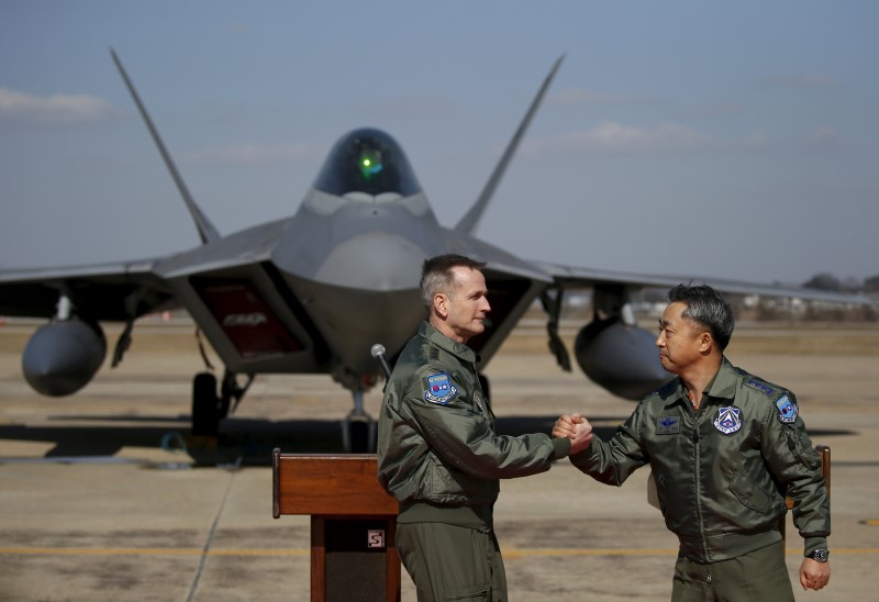 © Reuters. Lieutenant general Terrence O'Shaughnessy, 7th Air Force commander of the U.S. Forces to Korea, and South Korean Air Forces Commander Lee Wang-geun shakes hands after a media briefing in front of a F-22 stealth fighter jet at Osan Air Base in Pyeongt