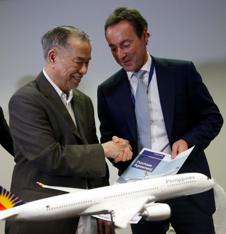 © Reuters. Airbus President and CEO Bregier shakes hands with Philippines Airlines Chairman Tan after a signing ceremony at the Singapore Airshow at Changi Exhibition Center 