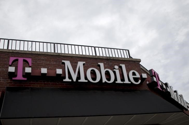 © Reuters. People pass by a T-Mobile store in the Brooklyn borough of New York