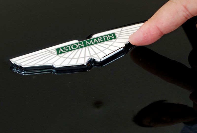 © Reuters. Sales Manager Raymond Liu points to an Aston Martin insignia on a car as he explains how each is handmade, at their showroom in Singapore