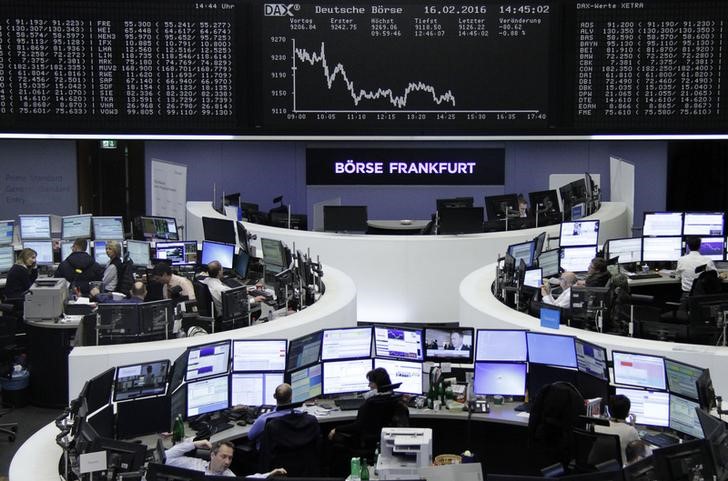 © Reuters. Traders work at their desks in front of the German share price index, DAX board, at the stock exchange in Frankfurt