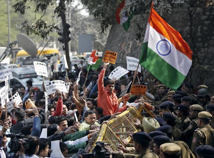 © Reuters. Activists from various Hindu right-wing groups shout slogans as they try to cross a police barricade during a protest against the students of JNU outside the university campus in New Delhi