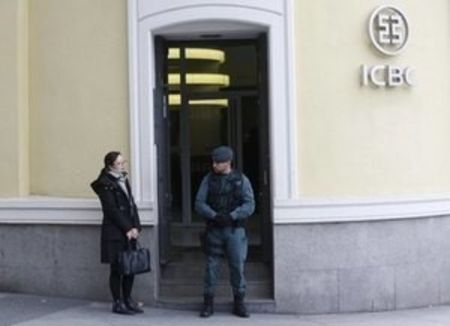 © Reuters. A Spanish Civil Guard officer stands in front of the entrance of the headquarters of Industrial and Commercial Bank of China during a raid in Madrid