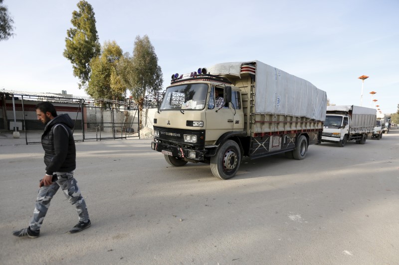 © Reuters. A convoy carrying humanitarian goods wait to enter the besieged area of Moudamiya Al Sham in the suburbs of Damascus