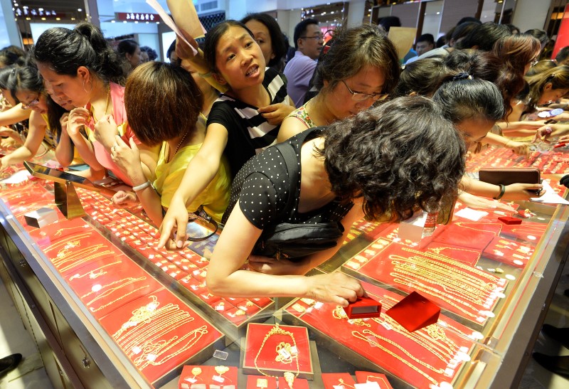 © Reuters. Customers flock to buy gold accessories at a gold store on sale in Taiyuan