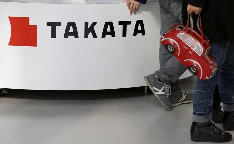 © Reuters. Visitors walk past a logo of Takata Corp on its display at a showroom for vehicles in Tokyo