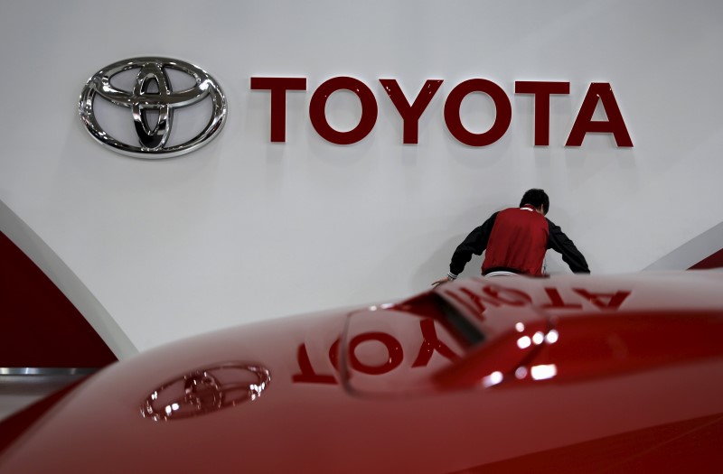 © Reuters. An employee works under a Toyota Motor Corp logo at the company's showroom in Tokyo