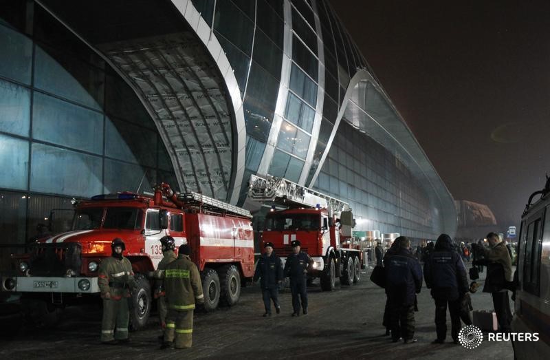 © Reuters. Firefighters work outside Moscow's Domodedovo airport