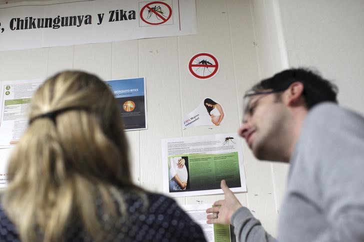 © Reuters. People read information on Zika virus and other mosquito-borne diseases at the Department of Health in San Juan