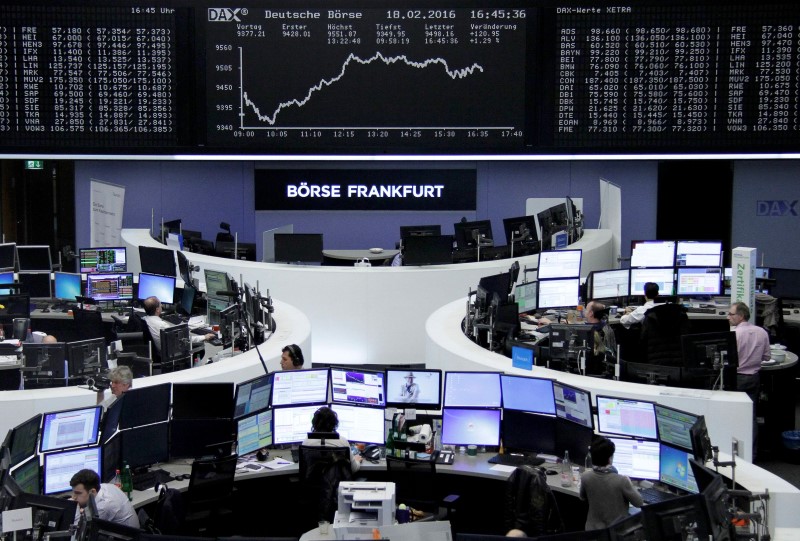 © Reuters. Traders work at their desks in front of the German share price index, DAX board, at the stock exchange in Frankfurt