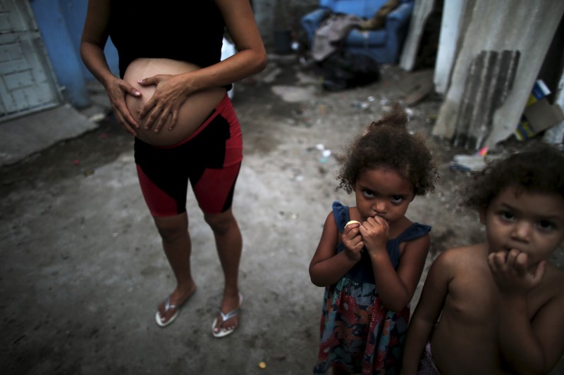 © Reuters. Patricia Araújo, grávida de sete meses, posa para foto ao lado de crianças perto de sua casa em uma palafita de Recife