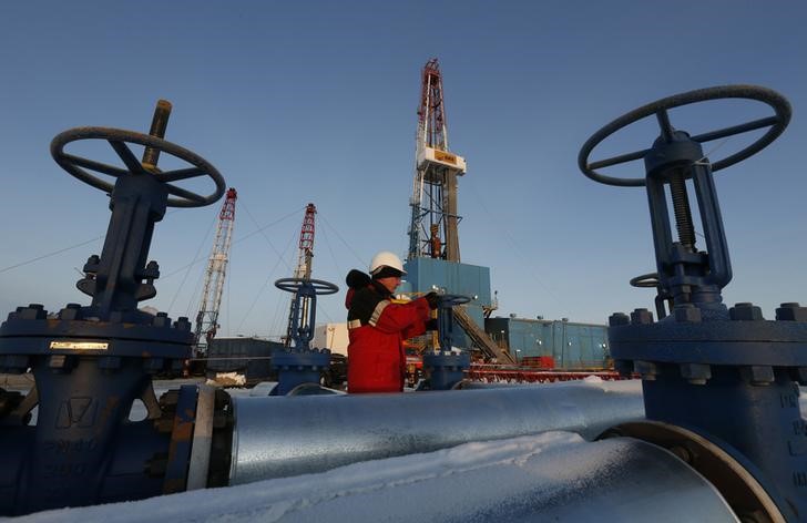 © Reuters. Рабочий поворачивает вентиль нефтепровода на месторождении Имилорское, принадлежащем Лукойлу