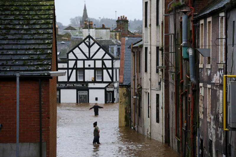 © Reuters. People wade through a flooded street in Dumfries