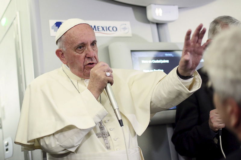 © Reuters. Pope Francis gestures during a meeting with the media onboard the papal plane while en route to Rome