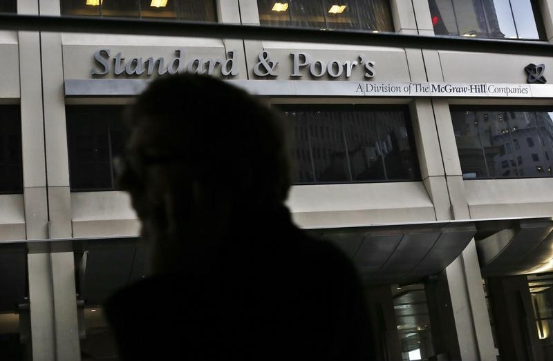 © Reuters. A man walks past the Standard and Poor's building in New York's financial district