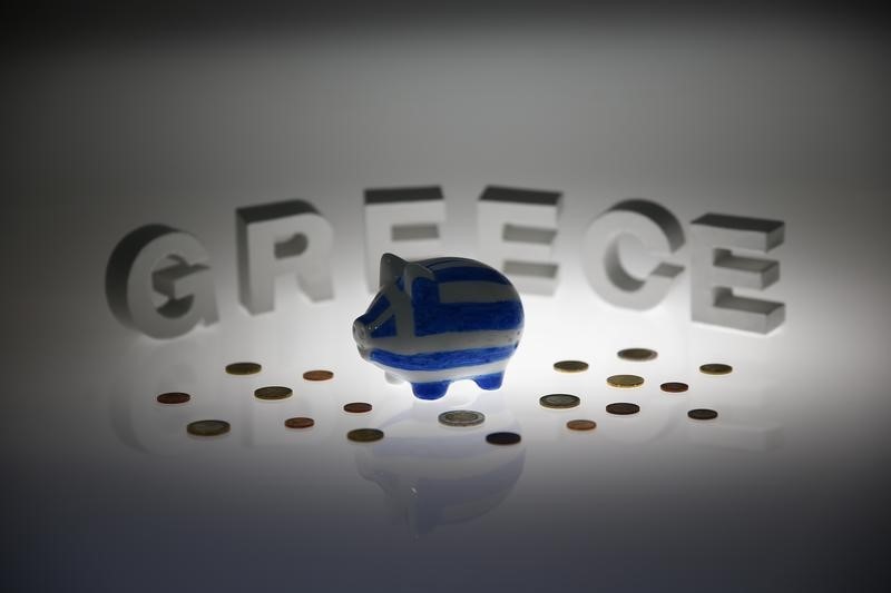 © Reuters. Piggybank painted in colours of Greek flag stands in front of letters spelling word 'GREECE' in this picture illustration taken in Berlin