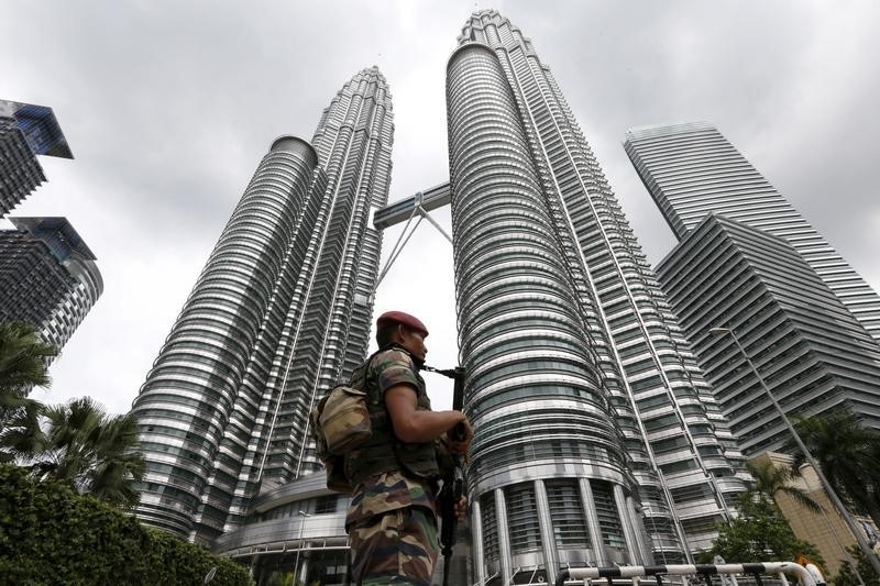 © Reuters. A Malaysian soldier patrols in front of the Petronas towers at the venue of the 27th ASEAN summit in Kuala Lumpur