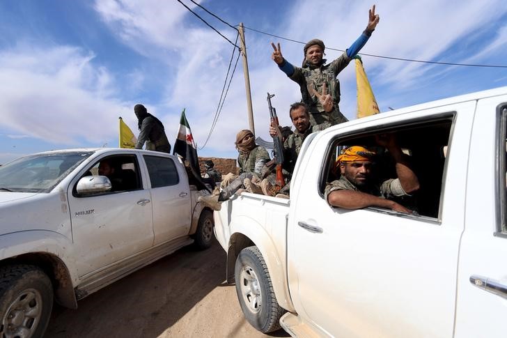 © Reuters. Grupos rebeldes sírios acenam na cidade de al-Shadadi 