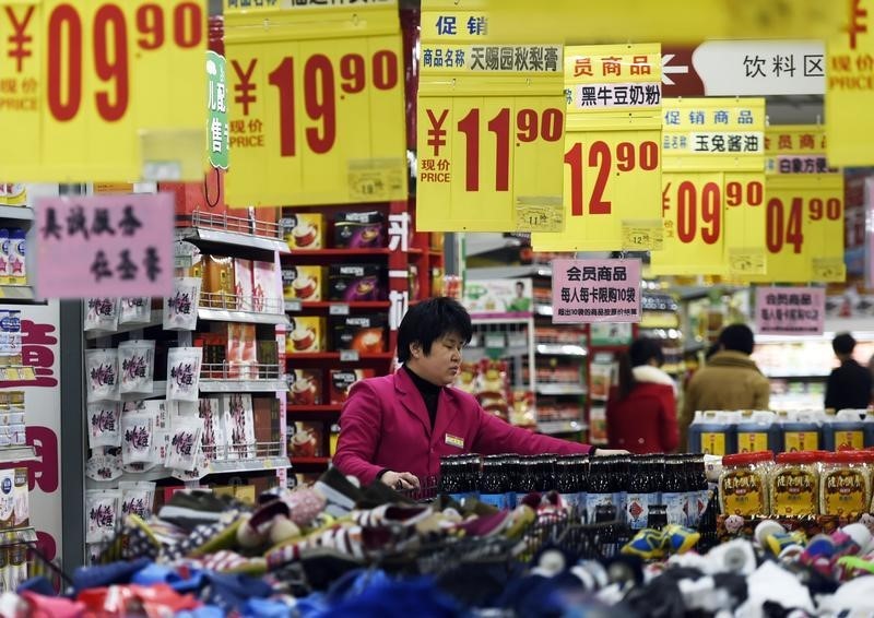 © Reuters. Vendedora arruma produtos em supermercado do Zouping, na China