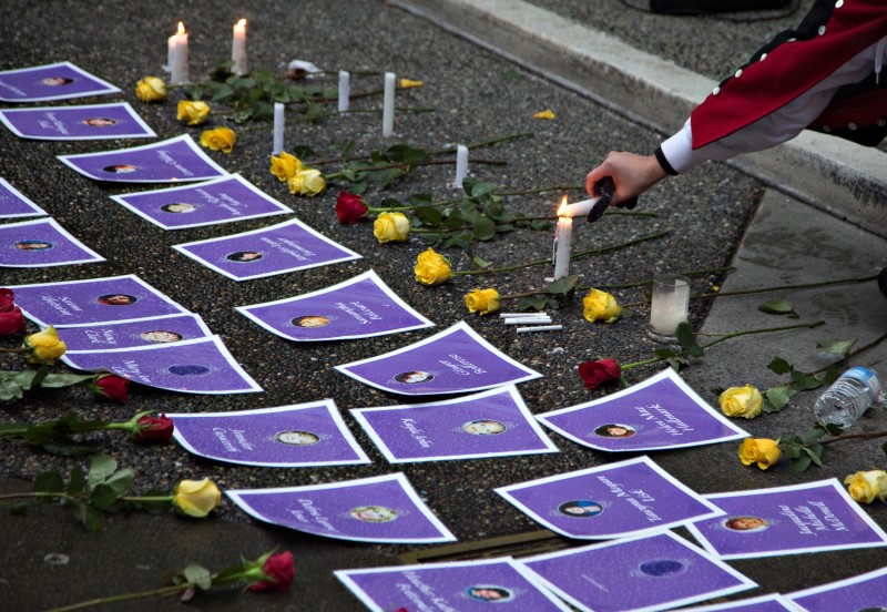 © Reuters. Supporter lights candles surrounding photos of murdered women outside Missing Women's Commission of Inquiry in Vancouver