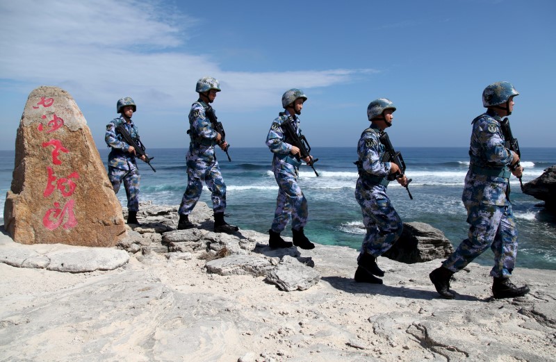 © Reuters. Soldiers of China's People's Liberation Army Navy patrol at Woody Island, in the Paracel Archipelago, which is known in China as the Xisha Islands