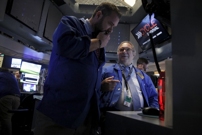 © Reuters. Traders work inside a post on the floor of the NYSE