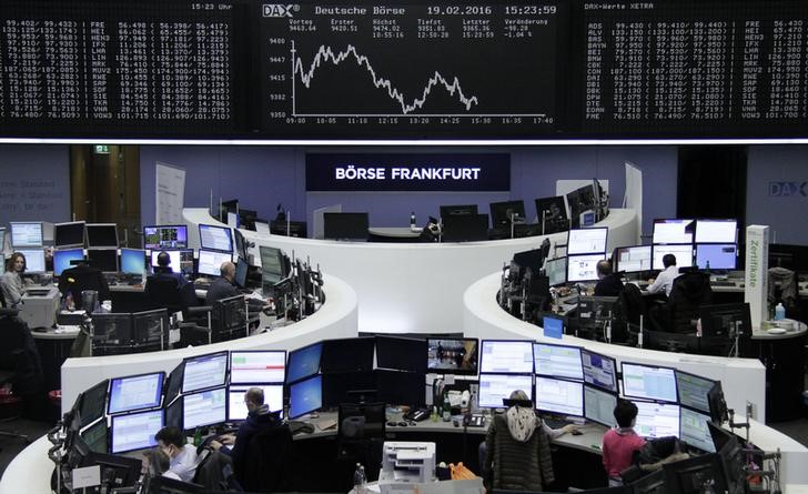 © Reuters. Traders work at their desks in front of the German share price index, DAX board, at the stock exchange in Frankfurt