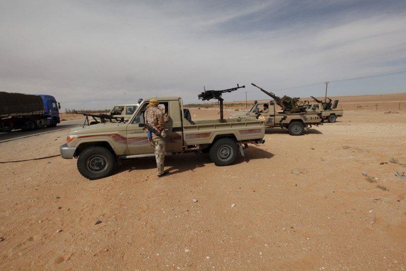 © Reuters. Libyan military vehicles are pictured at a checkpoint in Wadi Bey, west of the Islamic State-held city of Sirte