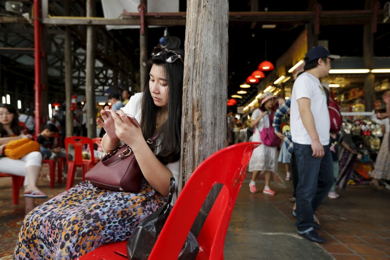 © Reuters. A Chinese tourist waits for a boat at a pier at Chao Phraya River in Bangkok