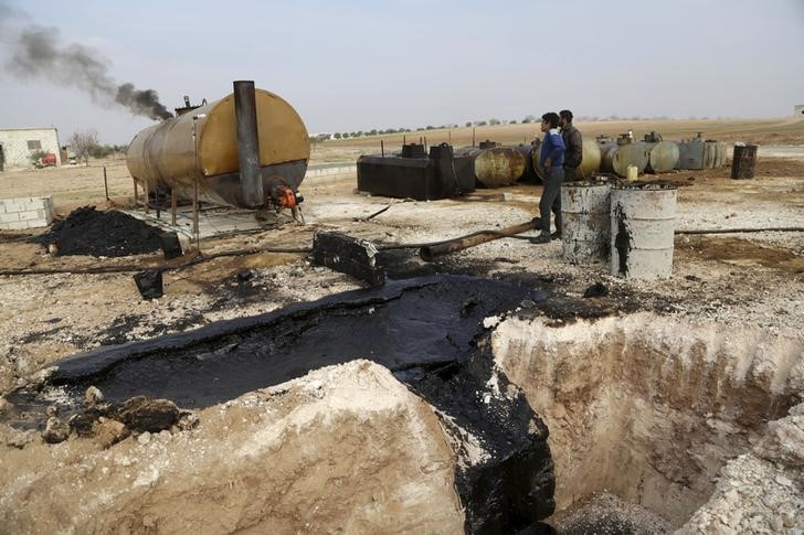 © Reuters. Men work at a makeshift oil refinery site in Marchmarin town, southern countryside of Idlib, Syria 