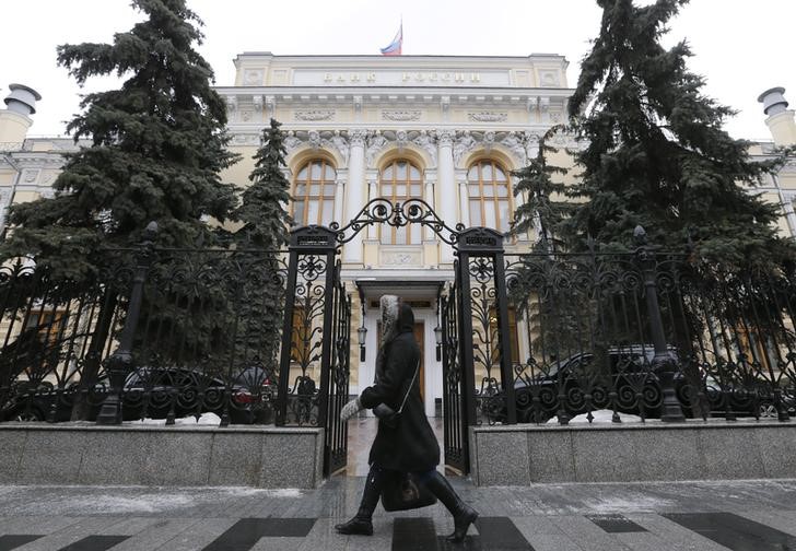 © Reuters. Woman walks near Central Bank headquarters in Moscow