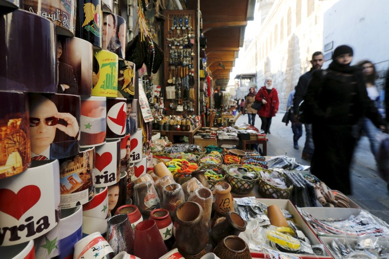 © Reuters. Souvenir mugs featuring Syria's President Assad, Russia's President Putin and Lebanon's Hezbollah leader Nasrallah are seen among other items for sale in old Damascus