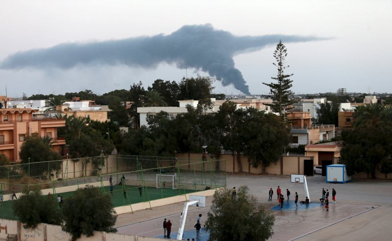 © Reuters. Black smoke billows in the sky above areas where clashes are taking place between pro-government forces, who are backed by the locals, and the Shura Council of Libyan Revolutionaries in Benghazi