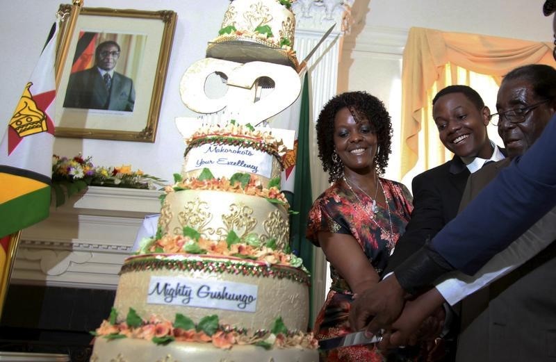 © Reuters. Zimbabwean President Robert Mugabe cuts a cake to celebrate his 92nd birthday