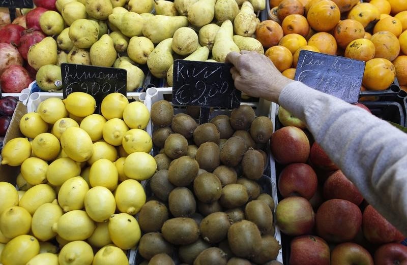 © Reuters. A fruit seller adjusts a price tag in a market in downtown Rome