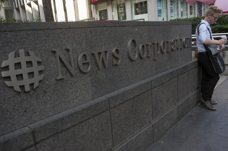 © Reuters. A passer-by stands in front of the News Corporation building in New York