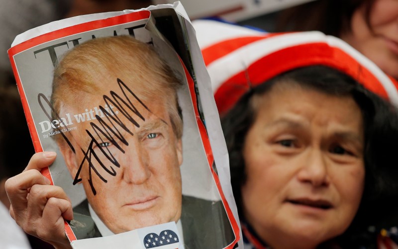 © Reuters. A supporter holds up a magazine that U.S. Republican presidential candidate Donald Trump signed for her during a campaign event in Radford