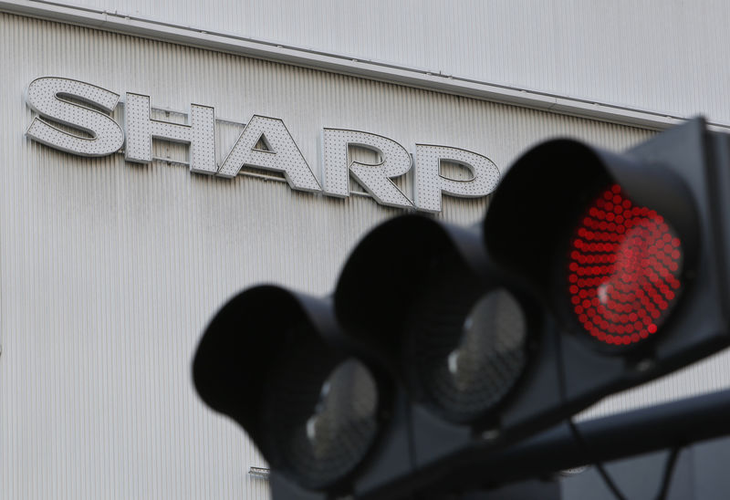 © Reuters. A logo of Sharp Corp is seen behind a traffic signal of red outside an electronics retail store in Tokyo