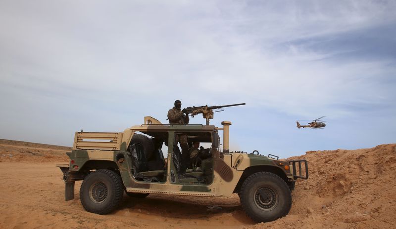 © Reuters. A Tunisian soldier holds his position during an exercise along the frontier with Libya in Sabkeht Alyun