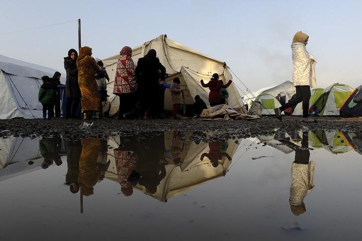 © Reuters. Refugiados e imigrantes aguardam em campo para atravessar a fronteira entre Grécia e Macedônia