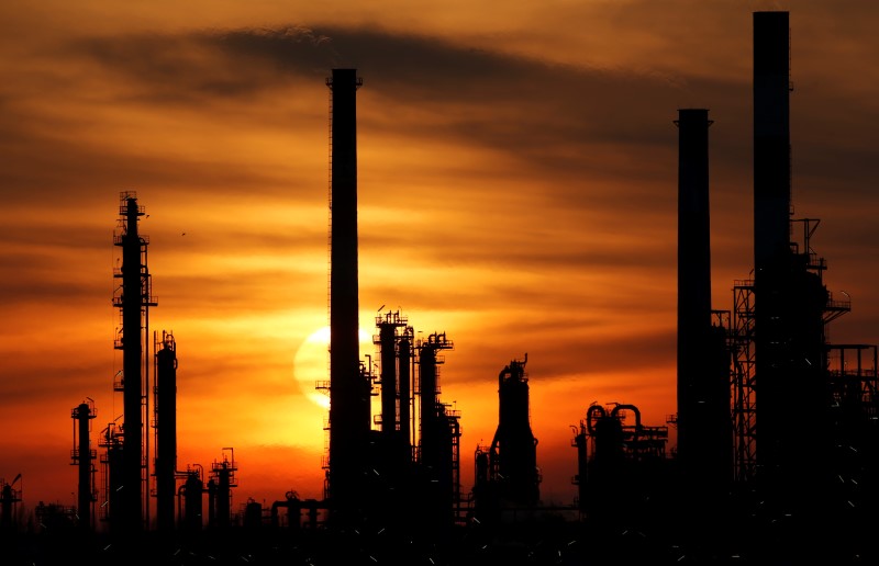 © Reuters. The sun sets behind the chimneys of the Total Grandpuits oil refinery southeast of Paris