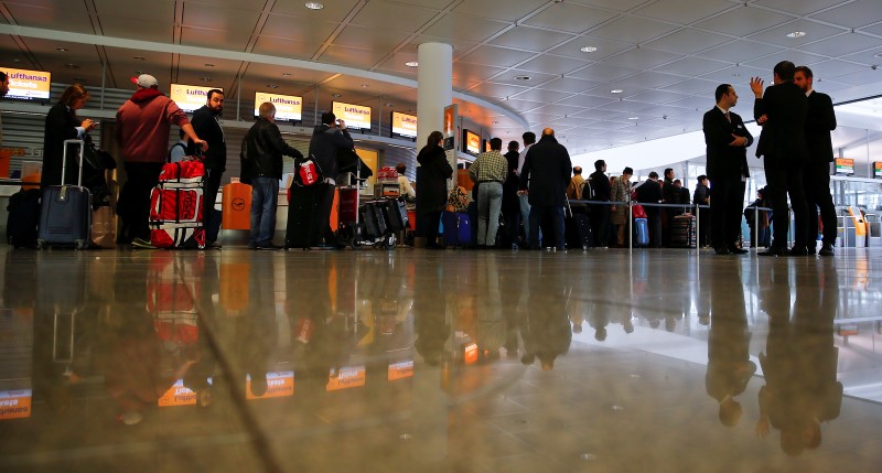 © Reuters. Travelers queue at a Lufthansa ticket counter during a strike at Munich's international airport