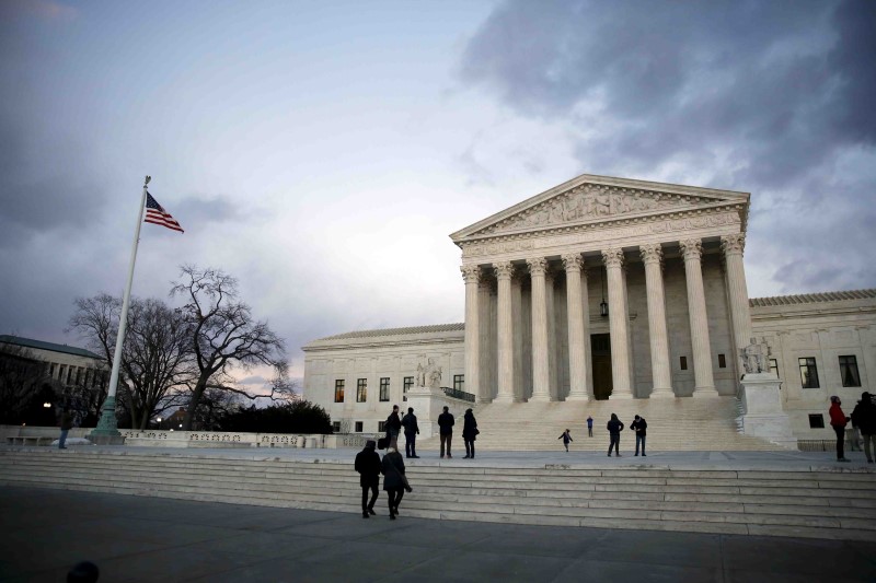 © Reuters. People stand outside the Supreme Court building at Capitol Hill in Washington D C