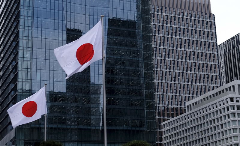 © Reuters. Japanese national flags flutter in front of buildings at Tokyo's business district