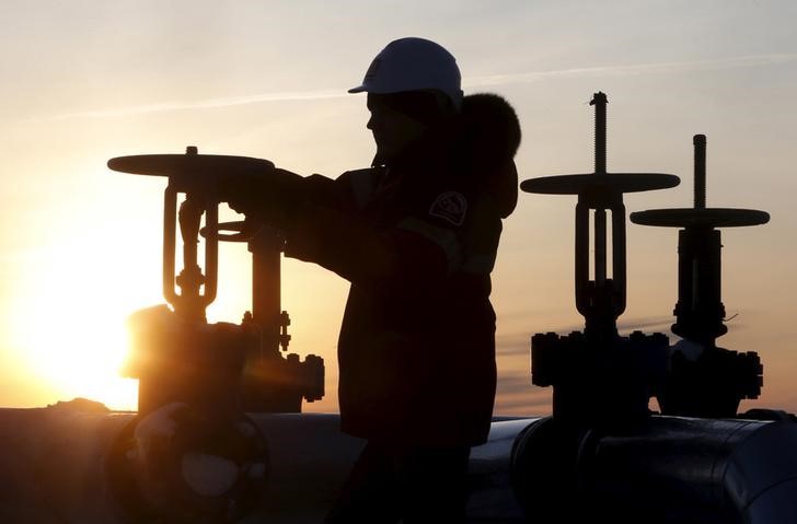 © Reuters. Worker checks valve of oil pipe at Lukoil company owned Imilorskoye oil field outside West Siberian city of Kogalym