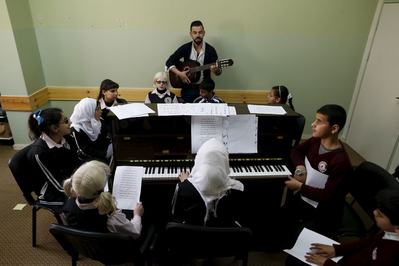 © Reuters. فلسطينيون يعلمون التلاميذ المكفوفين الانجليزية بالموسيقى