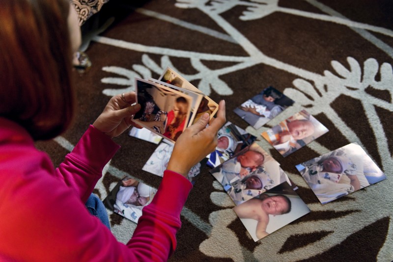 © Reuters. Former drug addict Pederson looks at family photos of her baby Avery, on the floor of her home in Devils Lake, North Dakota