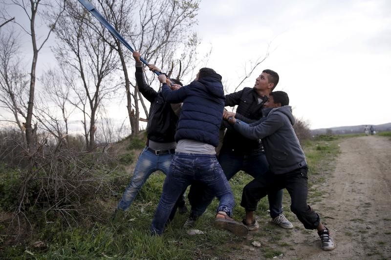 © Reuters. المتقاعدون يتقاسمون الخبز مع المهاجرين على حدود اليونان